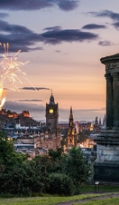 Fireworks at dusk in the sky over historic monument.